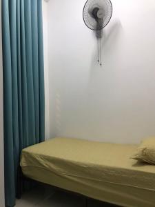 a room with a bed with blue curtains and a fan at MMG D'Bertam Homestay For Malay Only in Kampong Permatang Durian