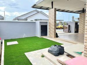 a backyard with a green lawn in front of a house at MMG D'Bertam Homestay For Malay Only in Kampong Permatang Durian +2 photos