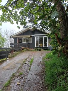 uma casa com uma estrada de terra em frente em HOSTEL Casa de campo Niña bosque em Valdivia