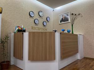 una sala de recepción con relojes en la pared en MOUNTAIN VIEW SAMARKAND, en Samarkand