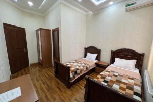 Habitación con 2 camas y mesa. en MOUNTAIN VIEW SAMARKAND, en Samarkand