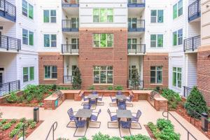 an apartment patio with tables and chairs in front of a building at Modish and Spacious Apartments at The Exchange on Erwin in Durham, North Carolina in Durham