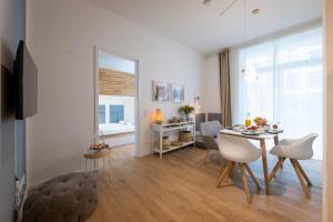 a living room with a table and chairs and a bedroom at Pure Berlin Apartments - for up to 5 guests near Uber Arena, central, stylish in Berlin