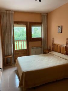 a bedroom with a large bed and two windows at Casa Miranda in Campo