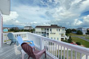 a balcony with two chairs and a house at San Flamingo 486 in Rodanthe