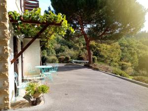 a patio with a table and chairs and a tree at Chambre calme en correze in Sainte-Fortunade