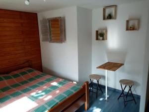 1 dormitorio con cama, mesa y taburetes en Chambre calme en correze, en Sainte-Fortunade
