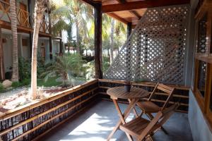 a porch with a table and a chair on it at Las Olas in Máncora