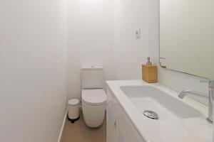 a white bathroom with a toilet and a sink at Apartamento da Musica - Boavista - OPENING in Porto