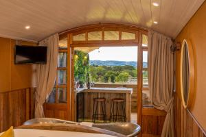 a room with a bar and a window with a view at Ashwood Shepherd Hut -Ockeridge Rural Retreats in Worcester