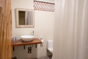 a bathroom with a sink and a toilet and a mirror at Las Olas in Máncora
