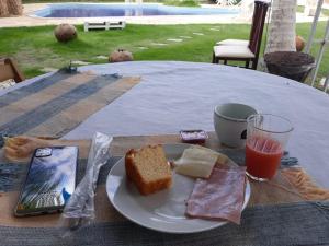 een bord brood en een glas sap op een tafel bij Hotel Pousada Summer Way in Aquiraz