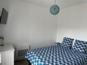 - une chambre avec un lit et une couette bleue dans l'établissement Gîte Le petit quartier, à Berson