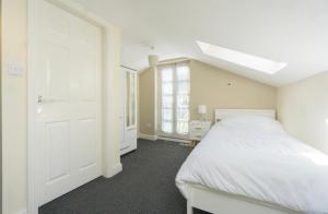 a white bedroom with a bed and a window at Roscoe House in Liverpool City Centre in Liverpool