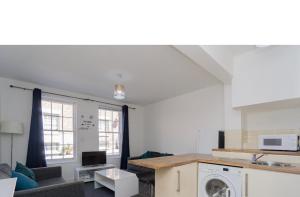 a kitchen and living room with a washer and dryer at Roscoe House in Liverpool City Centre in Liverpool