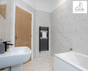 Apartment 1 - Beautiful 1 Bedroom Apartment Near Manchester في ورسلي: حمام أبيض مع حوض وحوض استحمام