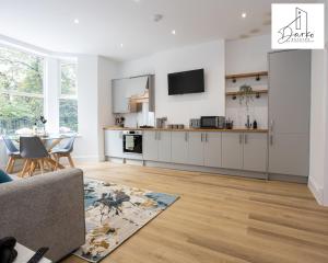a kitchen and living room with a couch and a table at Apartment 1 - Beautiful 1 Bedroom Apartment Near Manchester in Worsley