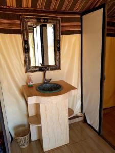 un baño con lavabo y espejo en Your berber camp, en Merzouga 48 fotos más