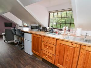 a kitchen with wooden cabinets and a counter top at Tancoed in Aberystwyth