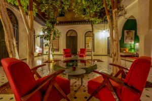 sala de estar con sillas rojas y mesa en Hotel & Spa Dar Sara, en Marrakech