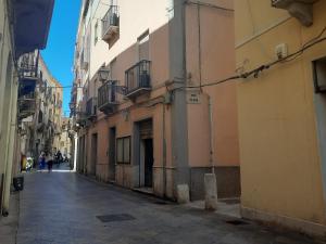 an alley with buildings and people walking down the street at Il Birillo Casa Vacanze in Trapani