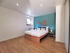 - une chambre avec un lit et un mur bleu dans l'établissement LA FERMETTE - Wifi - Parking - Netflix - Disney+, à Saint-Jorioz