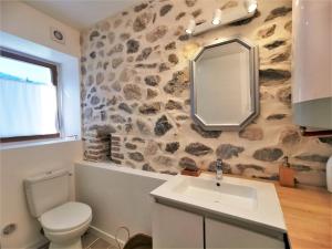 La salle de bains est pourvue d'un lavabo et d'un mur en pierre. dans l'établissement LA FERMETTE - Wifi - Parking - Netflix - Disney+, à Saint-Jorioz