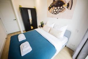 a bedroom with a large bed with a blue blanket at Cheerfully 1 Bedroom Serviced Apartment 52m2 -NB306C- in Rotterdam