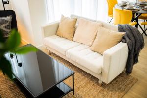 a living room with a white couch and a glass table at Cheerfully 1 Bedroom Serviced Apartment 52m2 -NB306C- in Rotterdam