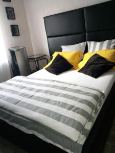 - un lit avec des oreillers en jaune et noir dans l'établissement # Prix "Travellers Awards 2023 et 2024" LAC LEMAN Chambre habitant Velos Viarhôna Geneve Annecy, à Valleiry