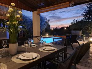 una mesa de madera con copas de vino en el patio en Villa Grace Felice, en Fažana