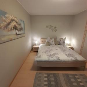 una camera da letto con un letto con due lampade sopra di Reitbergs Nest a Eugendorf Altre 37 foto