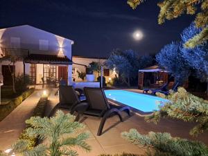 una casa con piscina por la noche en Villa Grace Felice en Fažana