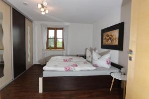 a bedroom with a bed with pink and white pillows at Säntisblick in Weitnau