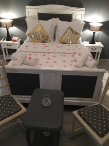 - une chambre avec un lit blanc et 2 chaises dans l'établissement Bienvenue chez Zina, à Vesoul