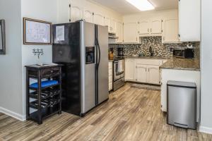 a large kitchen with a refrigerator and a table at 2B at the Beach in Carolina Beach
