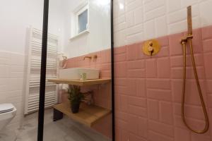 a pink bathroom with a shower and a toilet at Apollo Brașovul Istoric in Braşov