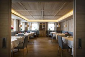 ein Restaurant mit Tischen und Stühlen in einem Zimmer in der Unterkunft Hotel Garni Panorama in Lech am Arlberg