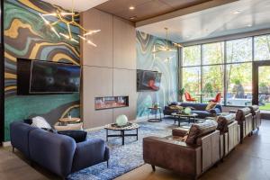 a living room with couches and a wall of windows at Locale Lofts The Gulch - Nashville in Nashville