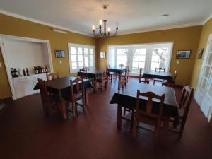 a dining room with tables and chairs and windows at Hostería de Ancasti in Ancasti