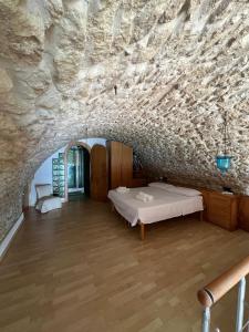 a room with a bed in a stone wall at Admirari in Tropea