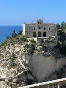 a building on top of a cliff next to the ocean at Admirari in Tropea