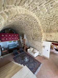 a living room with a stone wall and a couch at Admirari in Tropea