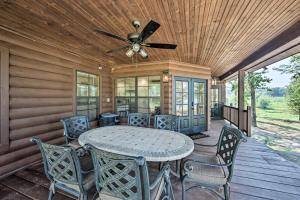 una mesa y sillas en un porche con ventilador de techo en The Bird Cabin Peaceful Refuge in East Texas, en Ben Wheeler
