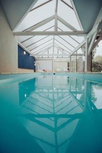 une grande piscine avec un grand plafond dans l'établissement Appartement de charme, Angers Belle-Beille, à Angers