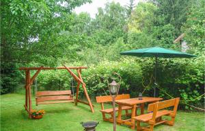 a picnic table with an umbrella and a table and benches at Cozy Home In Biskupice With Wifi in Biskupice