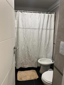 a bathroom with a toilet and a shower curtain at LUAN 1RO in Puerto Madryn