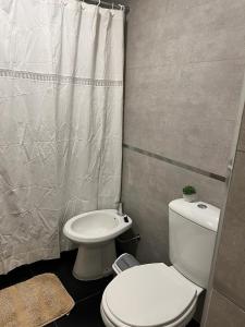 a bathroom with a white toilet and a sink at LUAN 1RO in Puerto Madryn