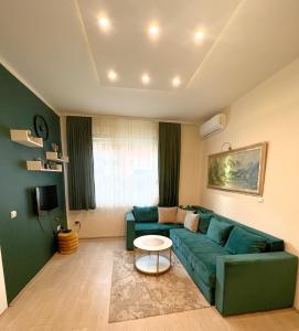 a living room with a green couch and a table at Dis apartman 2 in Kruševac