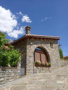 a small stone building with a window and flower boxes at Casa La Tornagua in Biescas